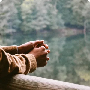 Une personne qui regarde un paysage, accoudé à une barrière