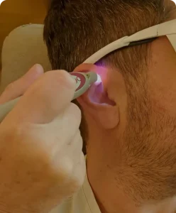 Véronique Yvrait, auriculothérapeute certfiée, applique un laser sur l'oreille d'un patient pour l'aider à réguler son appétit et perdre du poids.