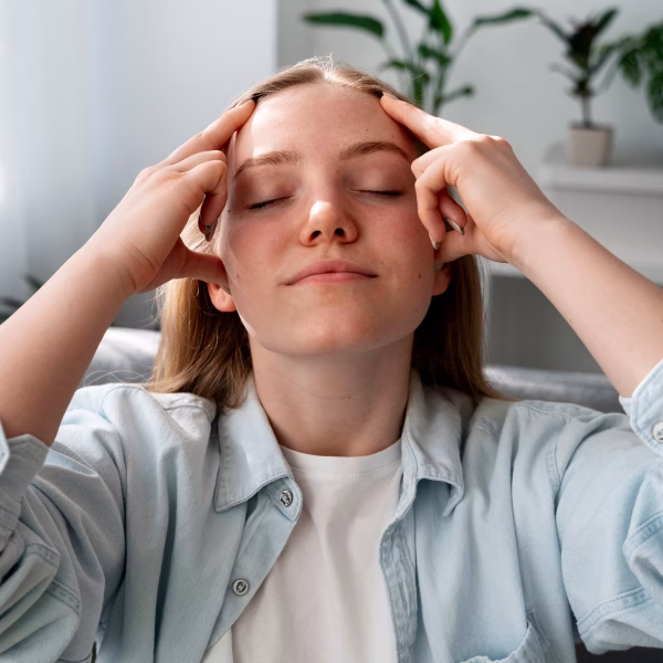 Une jeune femme est en train de pratiquer des techniques de relaxation pour s'auto-hypnotiser.